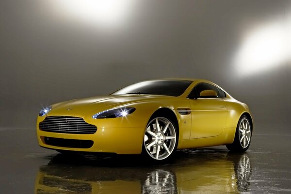 Voiture jaune aston martin v8. Miroir sur le sol