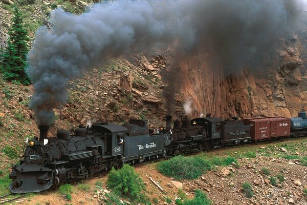 A steam locomotive is rushing on the mountain, and smoke is coming from the chimney