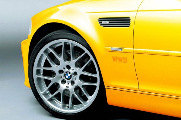 Close-up of the front wheel of a yellow BMW