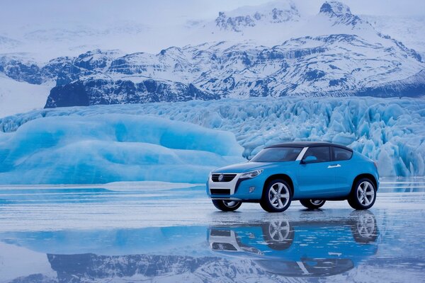 Volkswagen on ice against the backdrop of snow-capped mountains