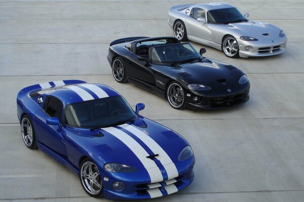 Three sports cars on concrete pavement