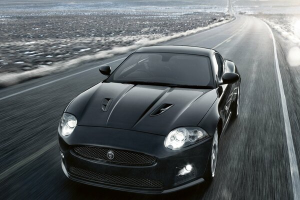 Jaguar car rides on the road at speed