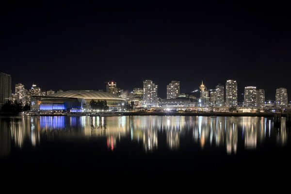 Luces de la ciudad nocturna que se reflejan en el agua