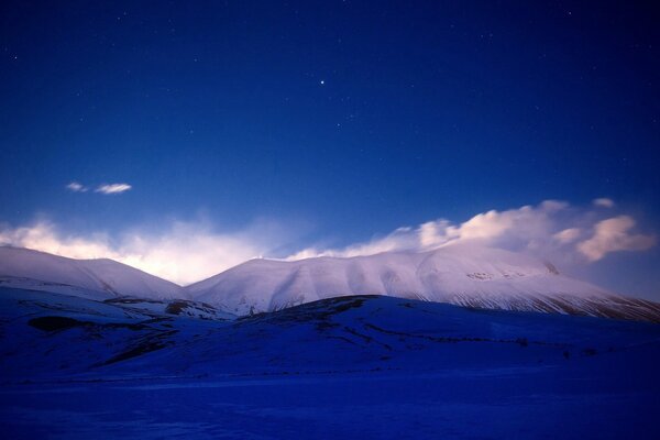 Слияние голубого неба со снежными вершинами гор
