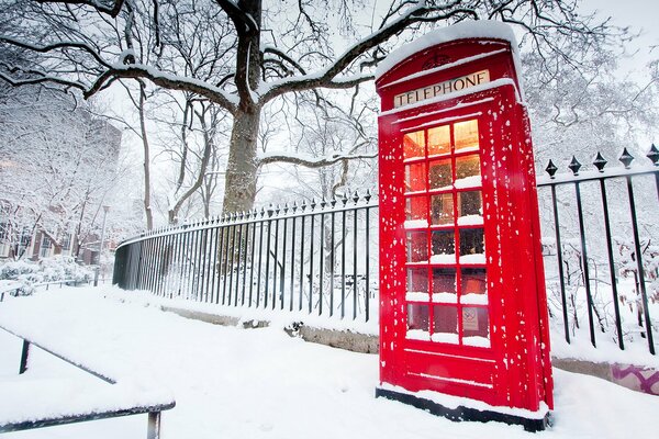 Red telephone booth on the sidewalk