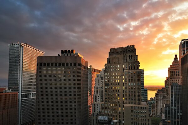 Puesta de sol y nubes sobre edificios Manhattan nueva York