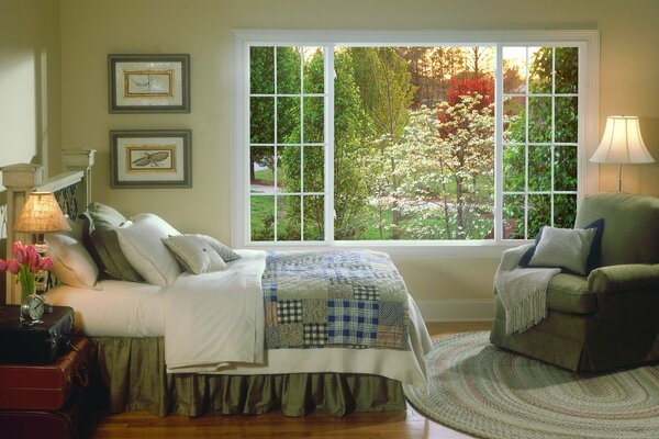 Elegante camera da letto con grande finestra che si affaccia sul verde