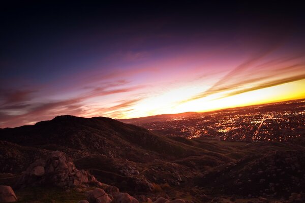 Unglaublicher Sonnenuntergang vom Hügel mit Blick auf die Stadt