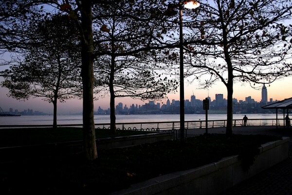 Romance, sunset on the river bank, metropolis in the distance