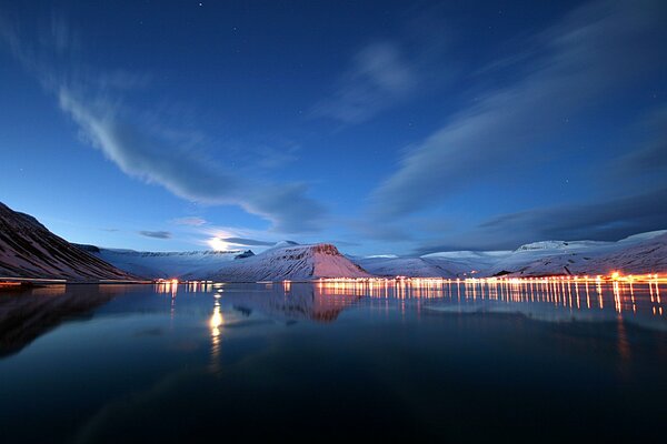 Snow-covered hills, pond and lights