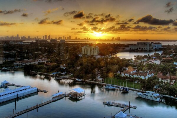 Pier against houses at sunset