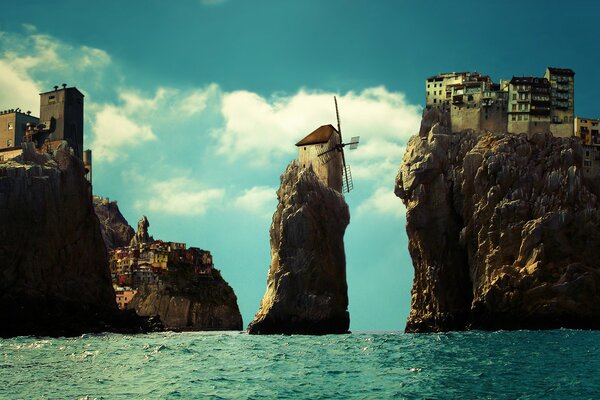 Дома на скалах в море и мельницей