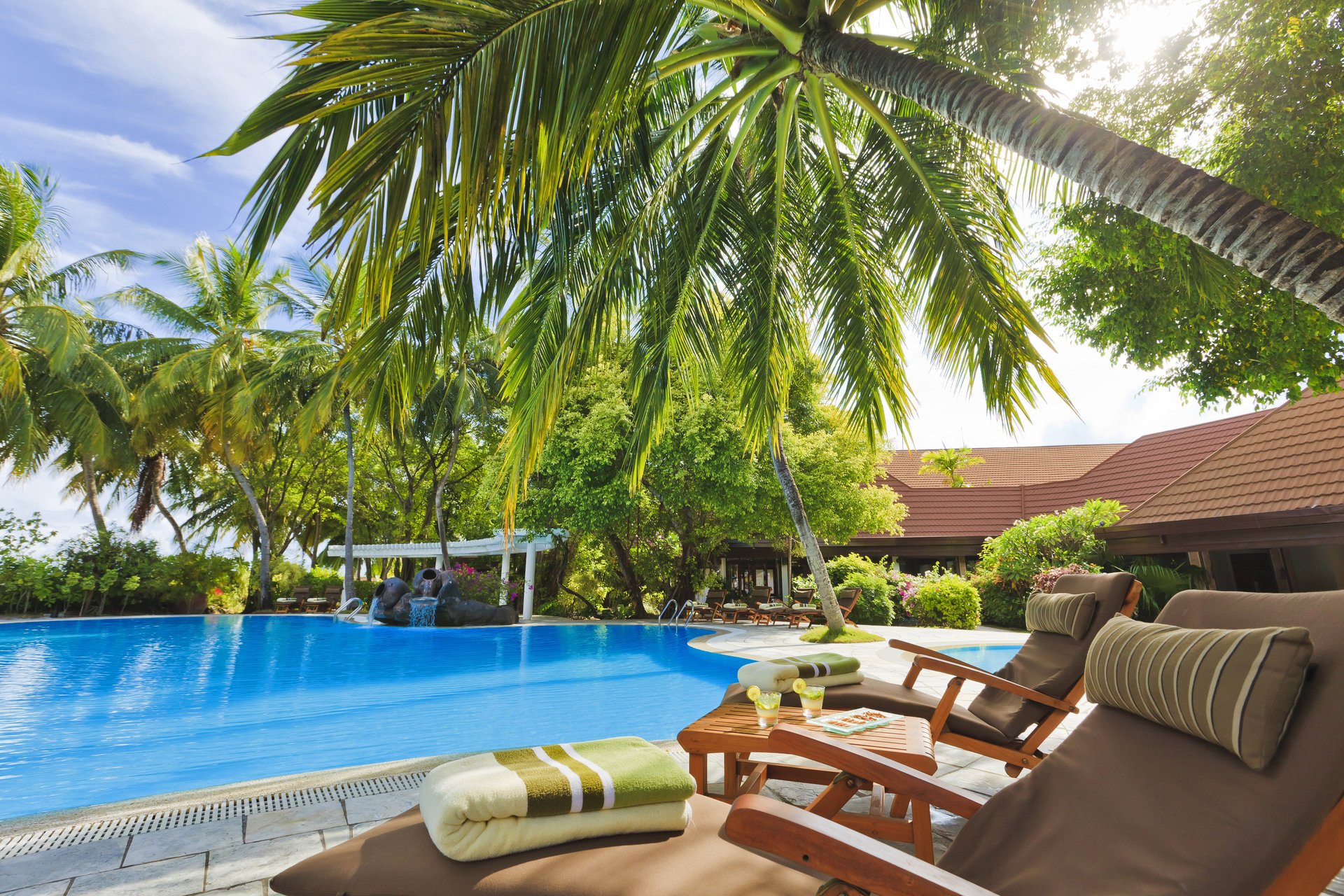 piscine extérieur hôtel table maldives chaises longues