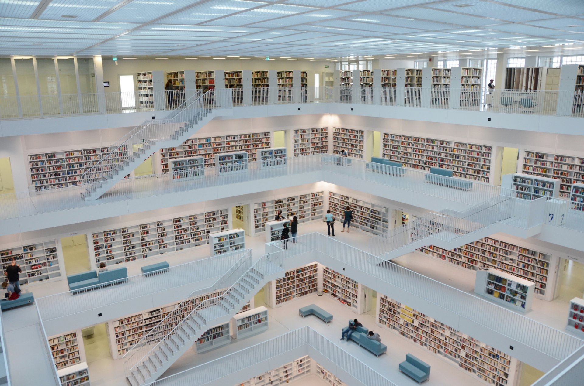 biblioteca libros escaleras personas sofá