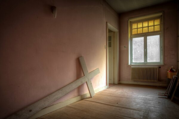 A deserted room with a wooden cross