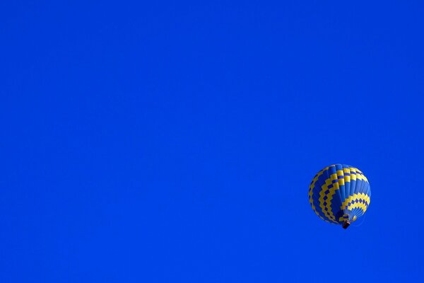 Воздушный шар с золотым узором на синем небе