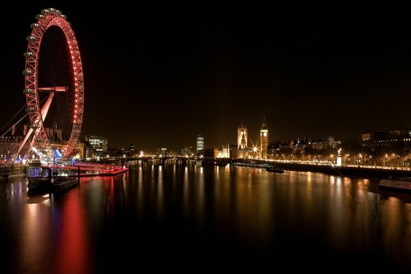 La Ruota panoramica si riflette nelle acque scure del fiume. Londra