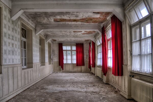 An empty retro style room with red curtains on the windows