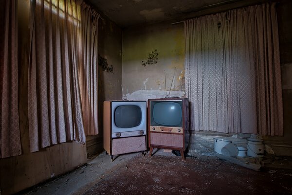 Dwa stare telewizory w ciemności