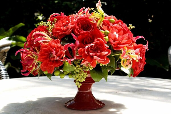 Un ramo de exuberantes flores rojas en un jarrón