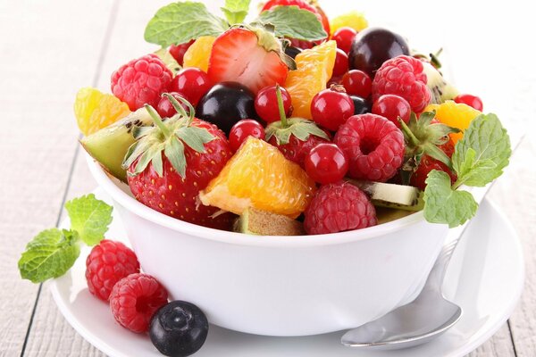 Ensalada de frutas y bayas en un plato blanco