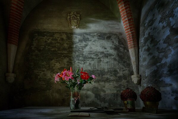 Flores brillantes en un jarrón en una habitación gris