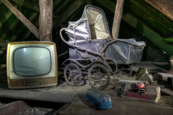 Viejo televisor y cochecito en el ático