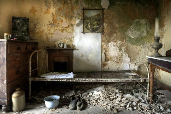 A bed against the wall in an abandoned house