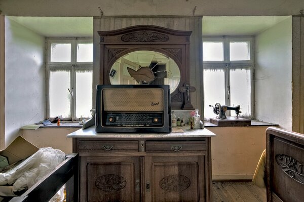 Старая комната с голыми окнами и раритетным радиоприемником