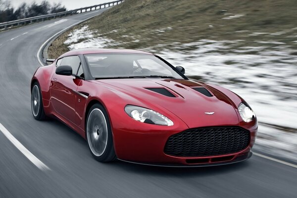 Roter Aston martin fährt aus der höhe