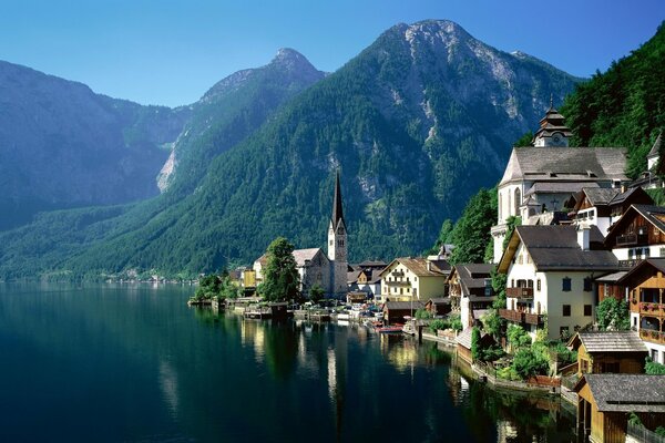 Rzeka i domy nad jeziorem wśród gór w Austrii