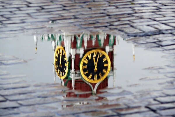 Reflet de l horloge sur les tours du Kremlin dans une flaque d eau