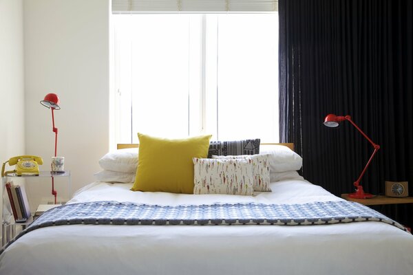 Спальня с кроватью и желтой подушкой