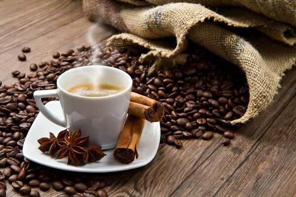 Tazza di caffè con cannella su uno sfondo di chicchi di caffè