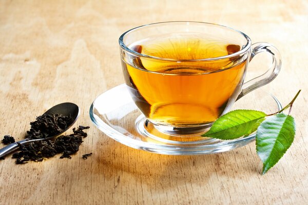 Tea in a mug and saucer. leaves on a saucer