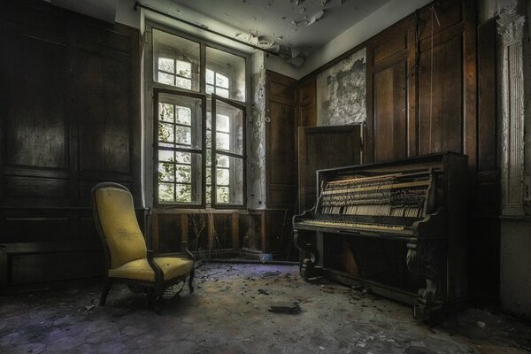 An armchair and a piano in an abandoned house