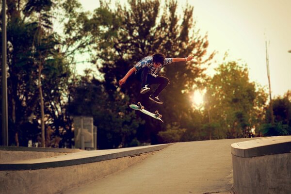 A skateboarder makes a tru at sunset