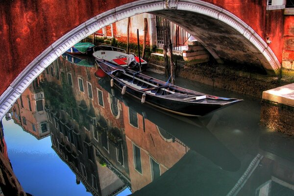 Barco veneciano bajo el puente rojo