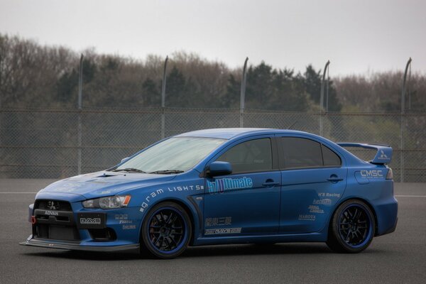 Mitsubishi blue on a background of trees