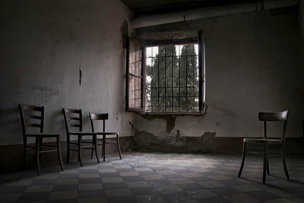 Stühle in einem verlassenen Zimmer mit Fenster