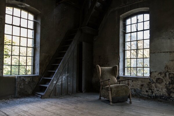 An abandoned house with a staircase to the attic and with windscreen windows