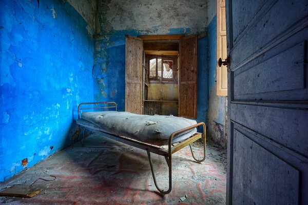 Hospital abandonado con cama de hierro