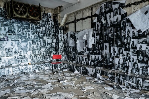 A room finished with photos and with a red chair