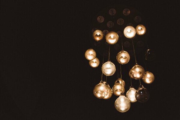 On a dark background, a chandelier with many lamps