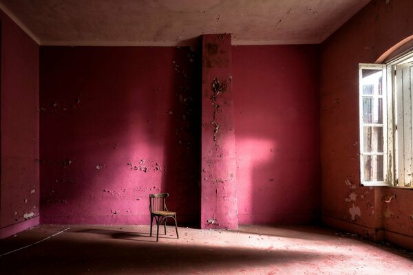 A red room with a window and a chair