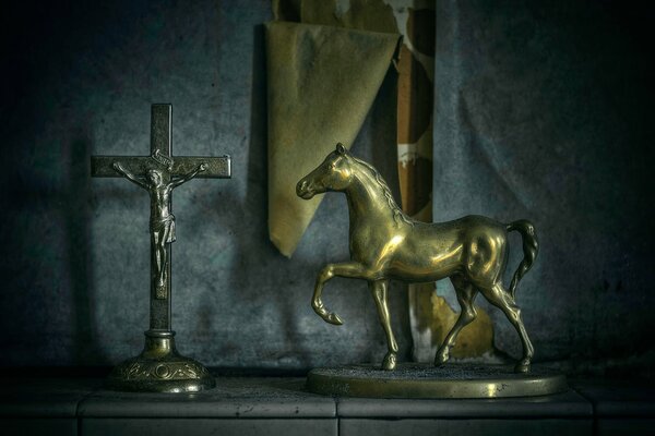 Sur le fond du papier peint qui s est éloigné du mur, il y a une statuette de cheval et un crucifix