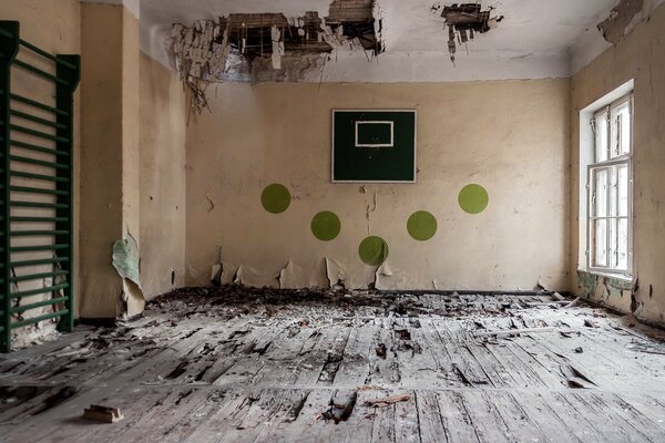 Gimnasio abandonado con anillo de baloncesto roto