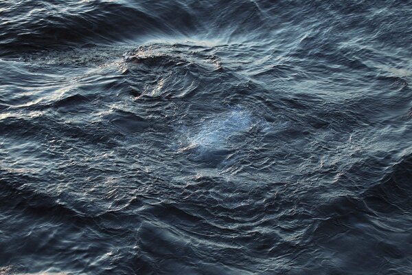 An image of waves on a lake creating a funnel out of waves