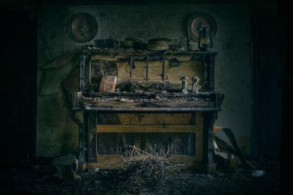 A room with a dismantled old piano and statuettes on it