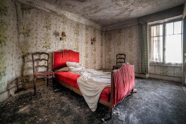 A bed in an old room with a window